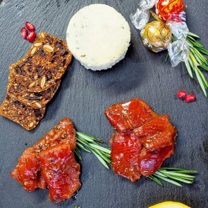 Open holiday gift box showing maple and peppered salmon with cheese and crackers