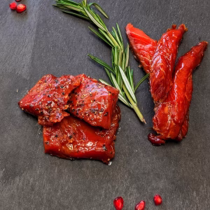 Wild Canadian smoked sockeye salmon candy strips and pepper-crusted nuggets on a slate board